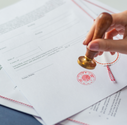 6 A hand stamping an official seal onto a notarized legal document