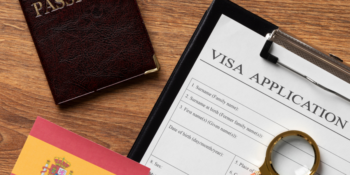 2 A passport, a visa application form, a Spanish flag, and a magnifying glass on a desk