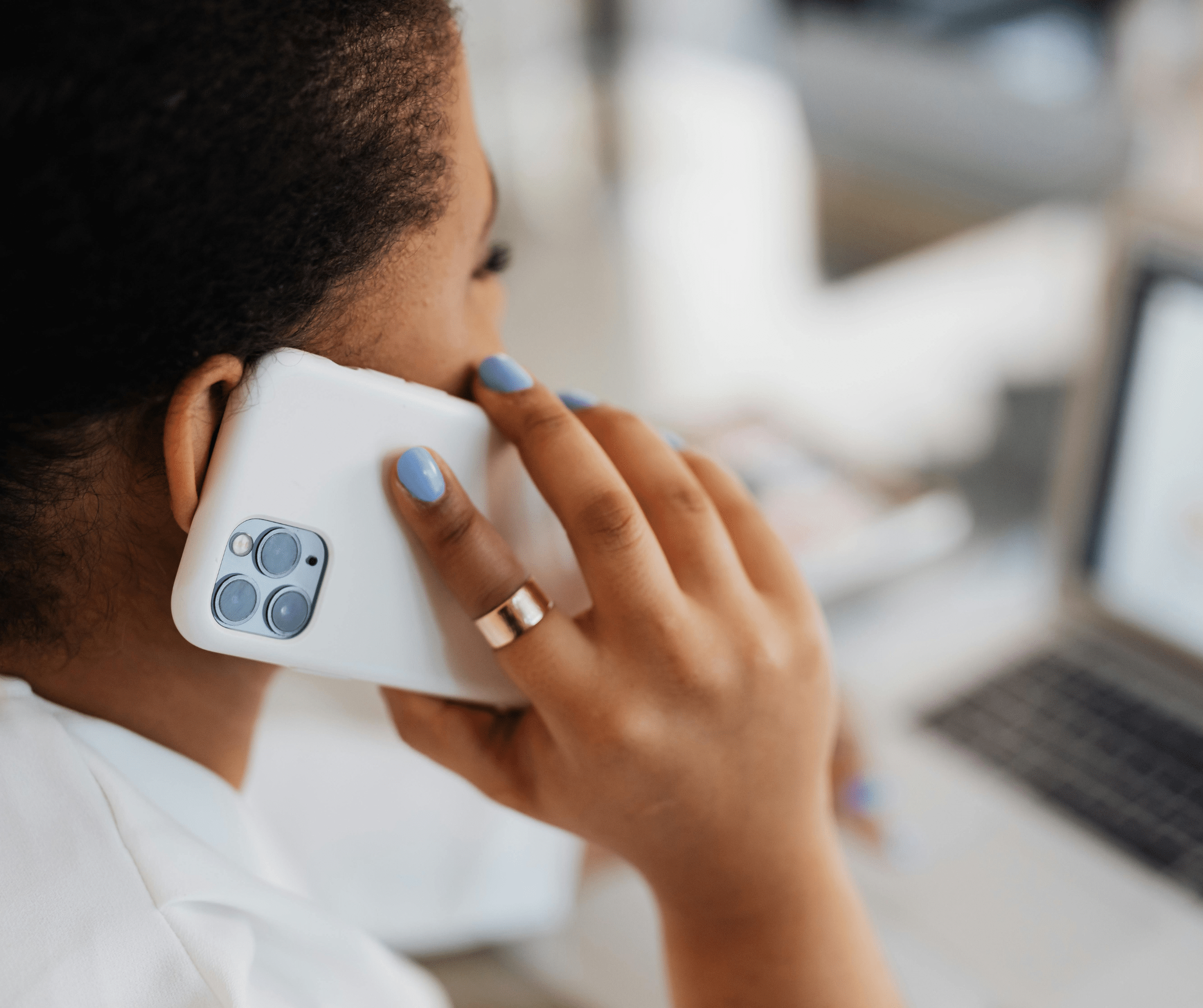 Woman talking on a white smartphone in an office setting