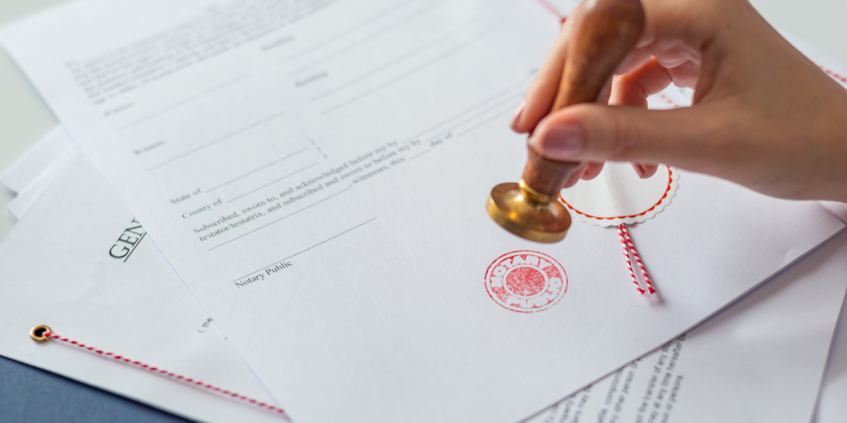 6 A hand stamping an official seal onto a notarized legal document